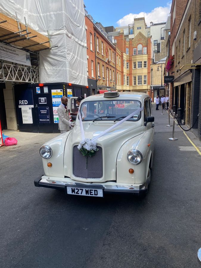 Classic Fairway wedding taxi with white rose bouquet and ribbons at the front, M27 WED