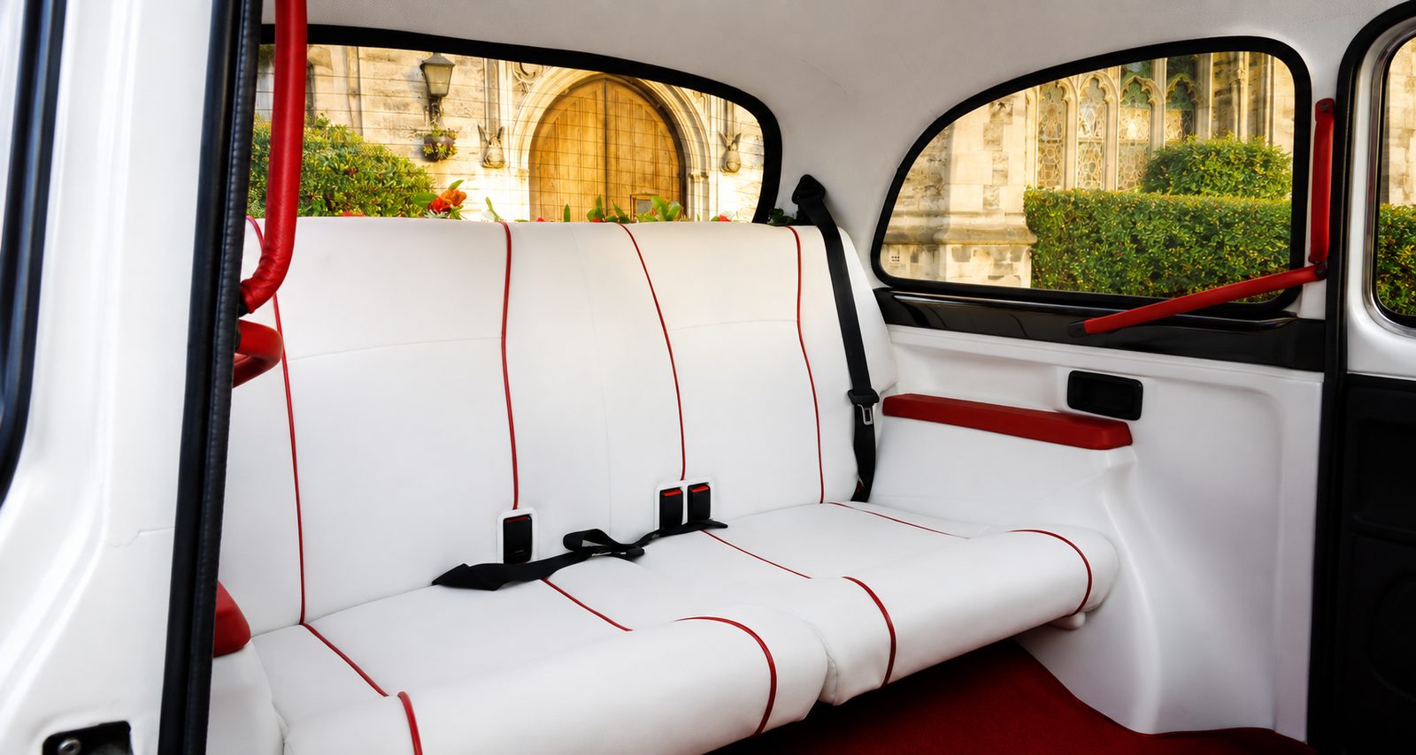 White leather rear seats with red piping inside the Classic Fairway wedding taxi