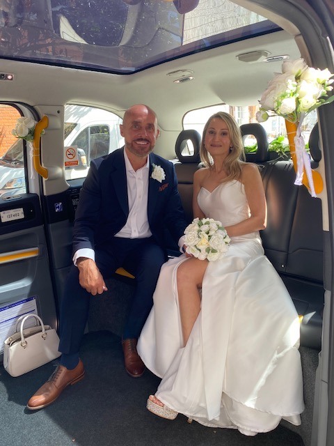Newlyweds seated inside the electric TXE wedding taxi