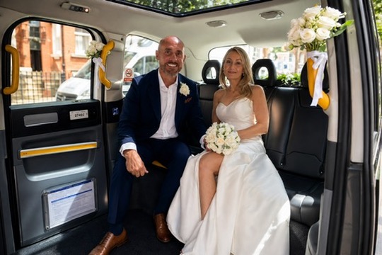 Newlyweds seated inside the electric TXE wedding taxi