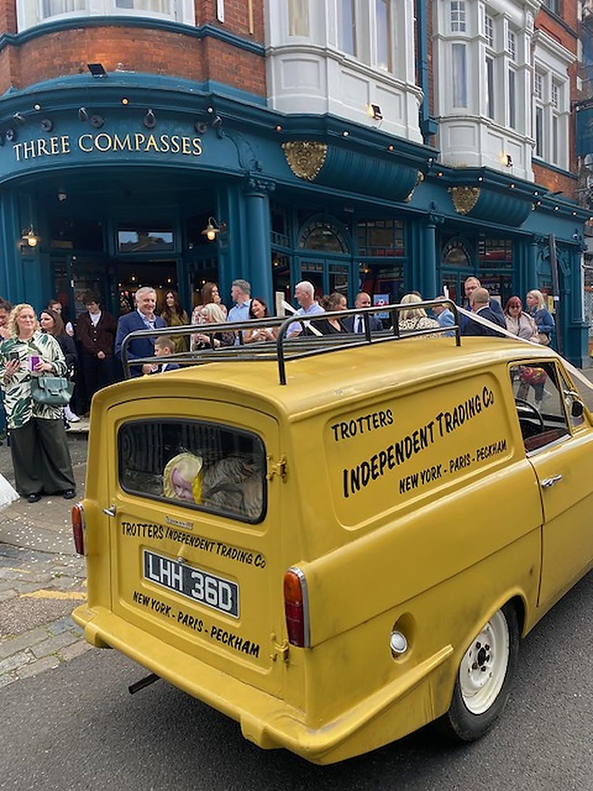 Yellow classic wedding car outside a London pub